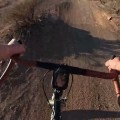 A view of handlebars on a dirt trail.